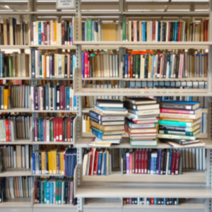Assorted library books on shelves, titles are blurred